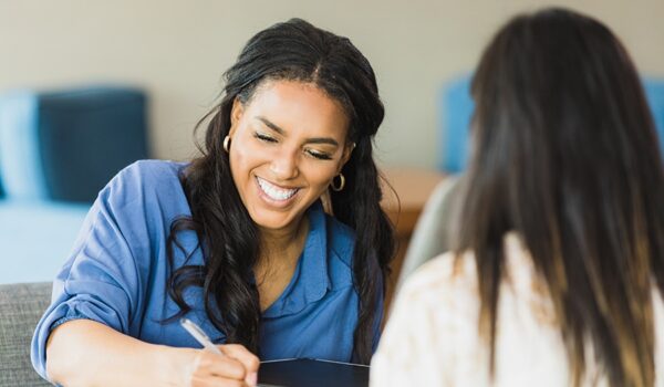 Female business owner smiles while conducting interview The mid adult female business owner smiles as she conducts an interview with the unrecognizable woman.