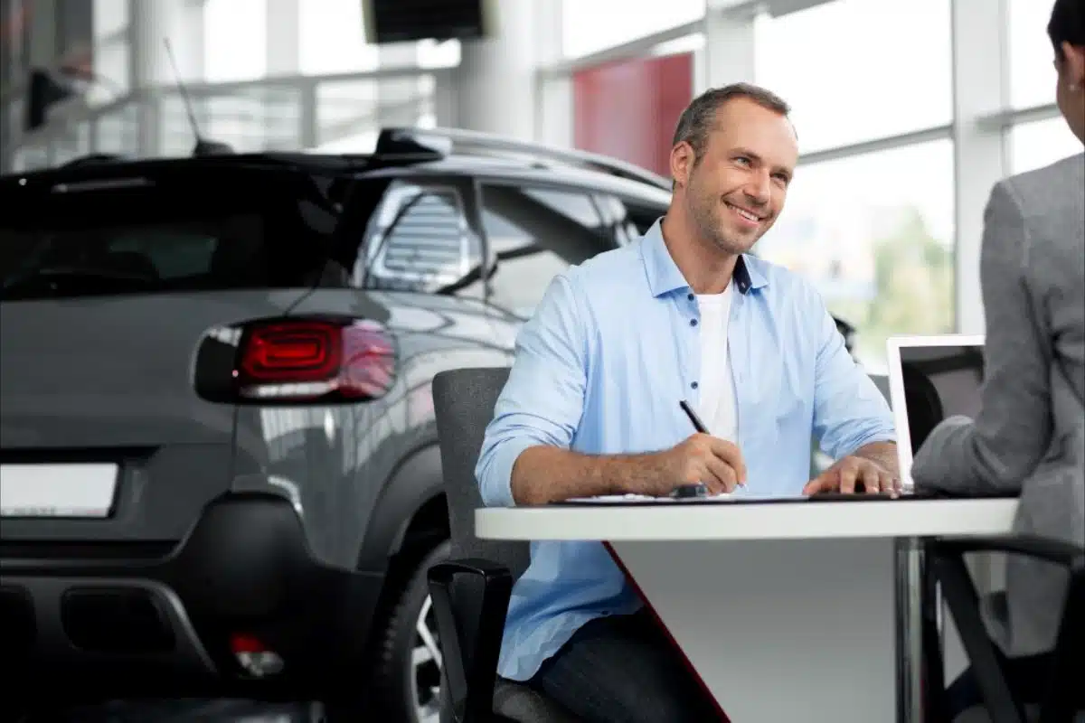 Man reviewing papers by a car