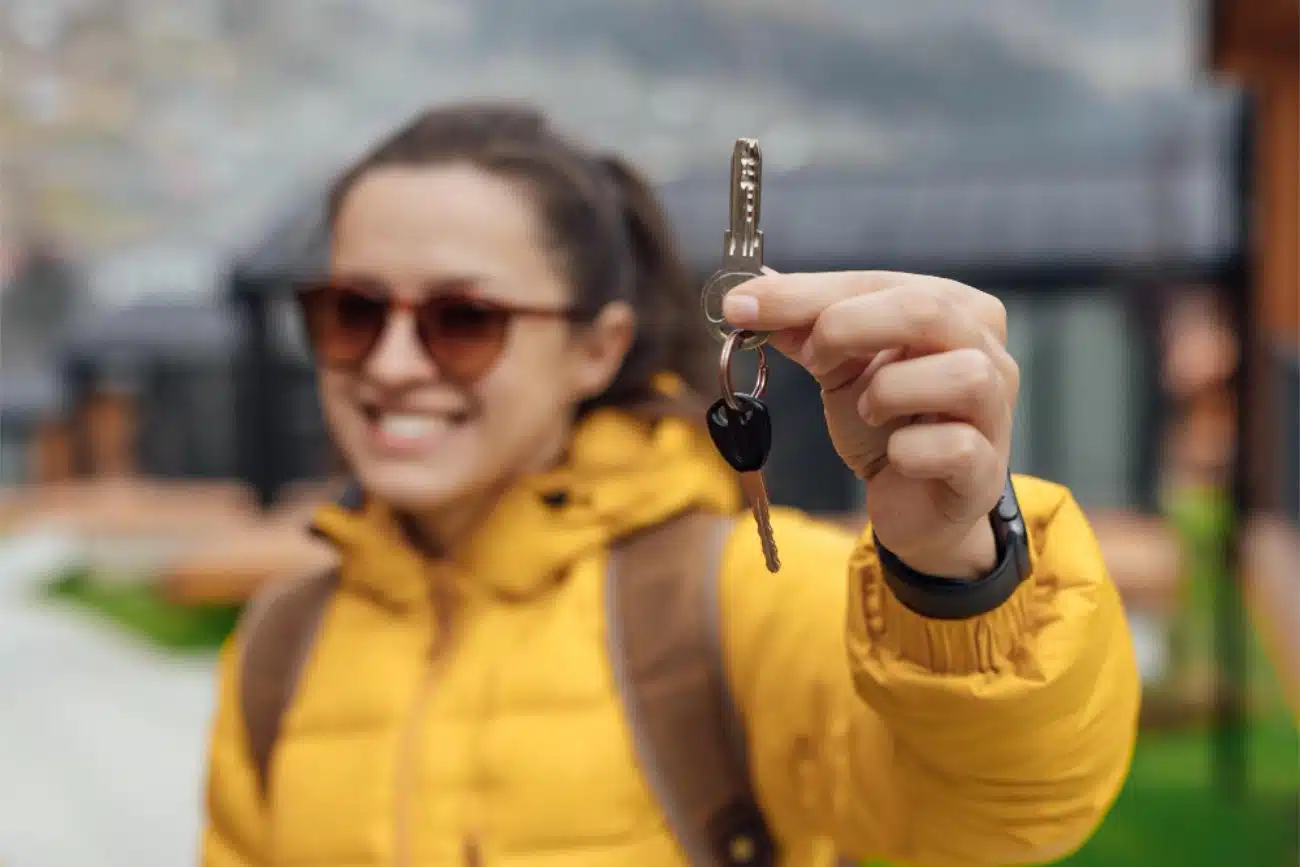 Person holding car keys in front of a car in an urban Jacksonville Florida setting, horizontal format, daytime